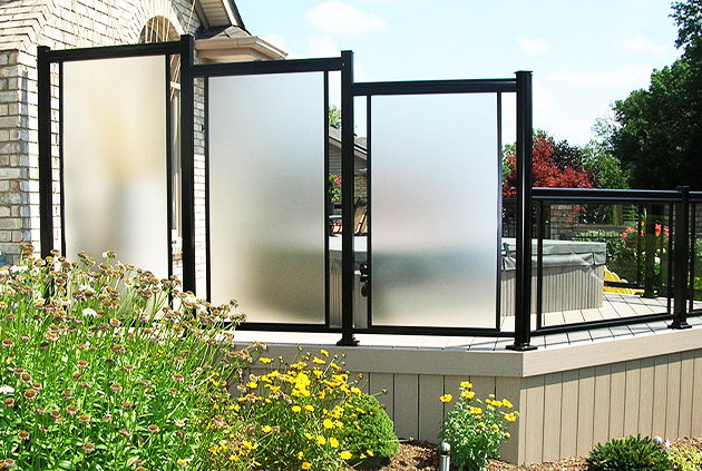 Black aluminum fencing with large privacy screens on custom deck.